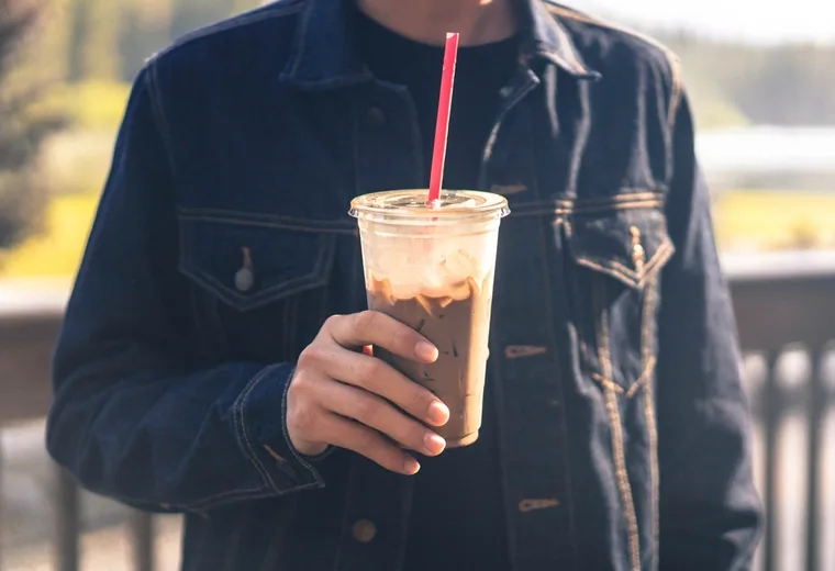 Iced coffee A hand holding an iced coffee with a straw